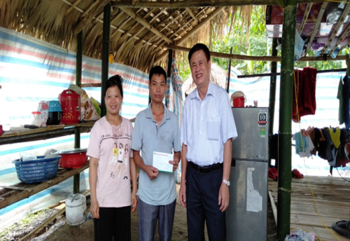 Đồng chí Nguyễn Ngọc Sơn - Phó Chánh Văn phòng điều phối nông thôn mới tỉnh trao quà cho gia đình anh Trưởng Văn Giàng